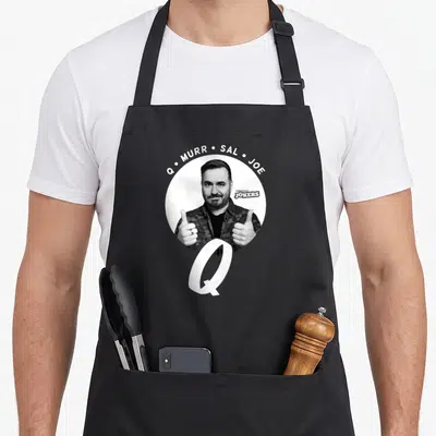 Impractical vinegar apron - Photo of Q giving thumbs up with Q Murr Sal Joe text and logo — shown on a black cotton canvas apron against a white background