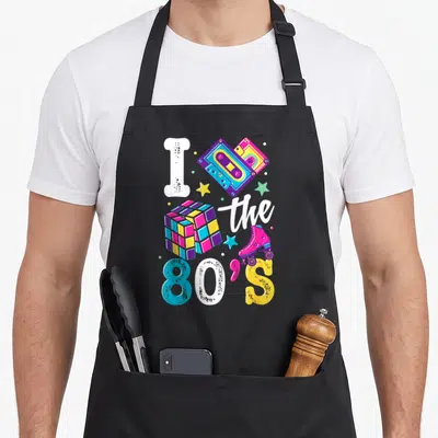 Supply 80s apron - I the 80'S graphic with cassette, cube, skate, and stars in pink blue yellow purple white — shown on a black cotton canvas apron against a white background