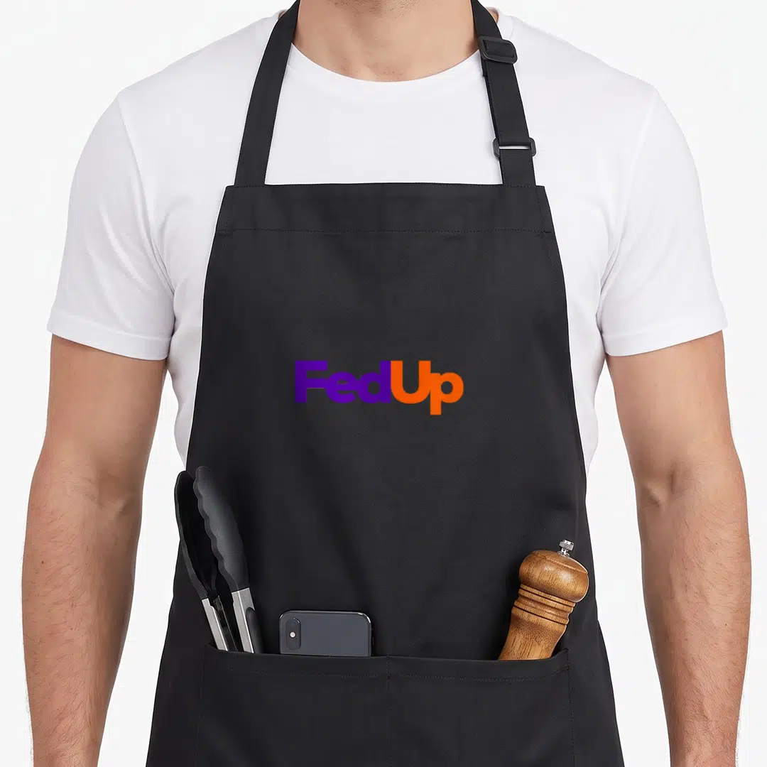 Fedup best class ever apron - Bold FedUp text in purple and orange block letters — shown on a black cotton canvas apron against a white background