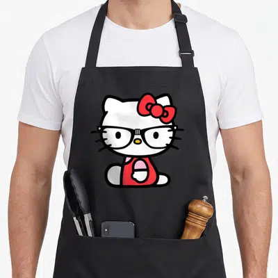 Cute glass nerd apron - Cartoon Hello Kitty wearing black glasses and red bow on white background — shown on a black cotton canvas apron against a white background