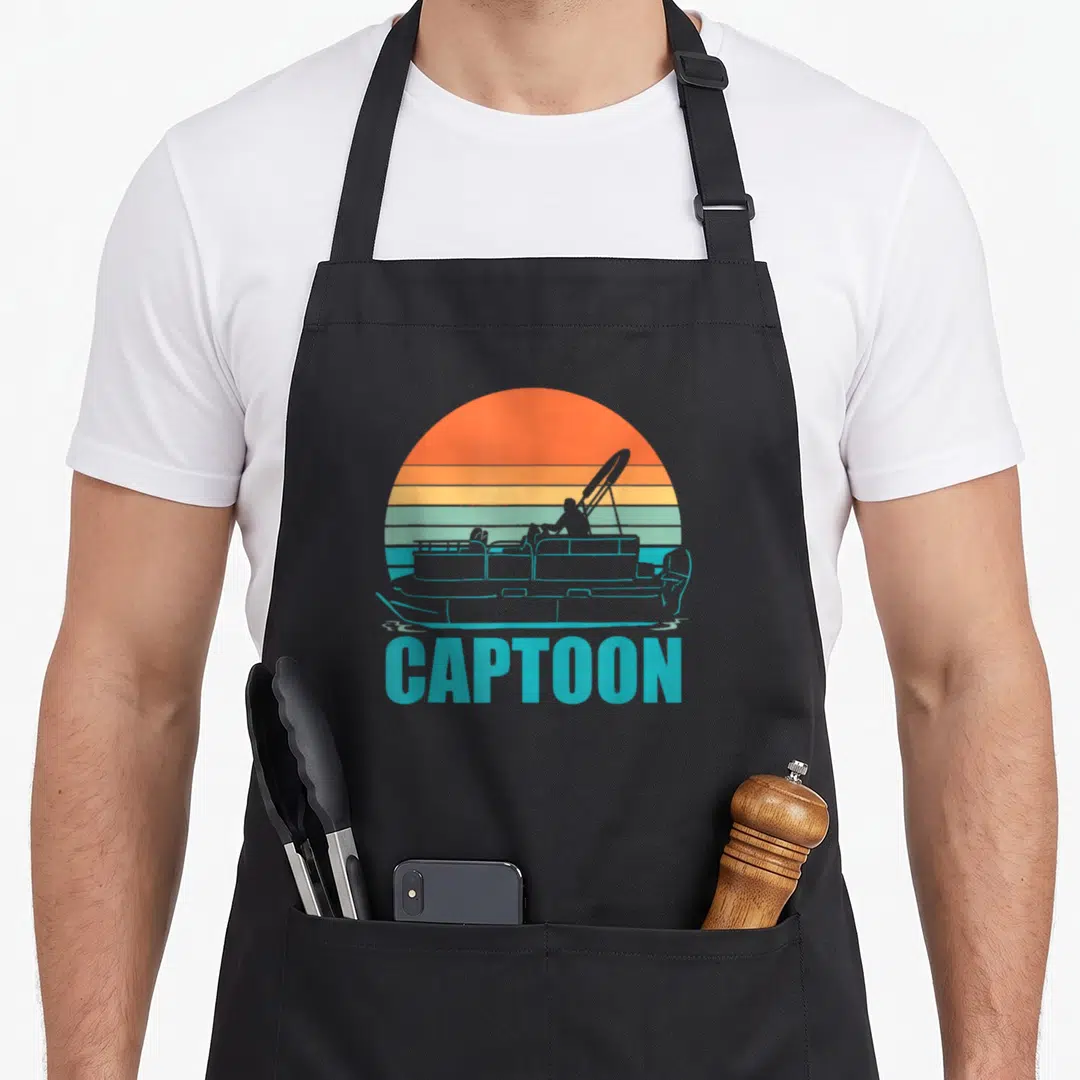 Boating pontoon apron - Retro CAPTOON text under pontoon silhouette against orange and blue striped sun — shown on a black cotton canvas apron against a white background
