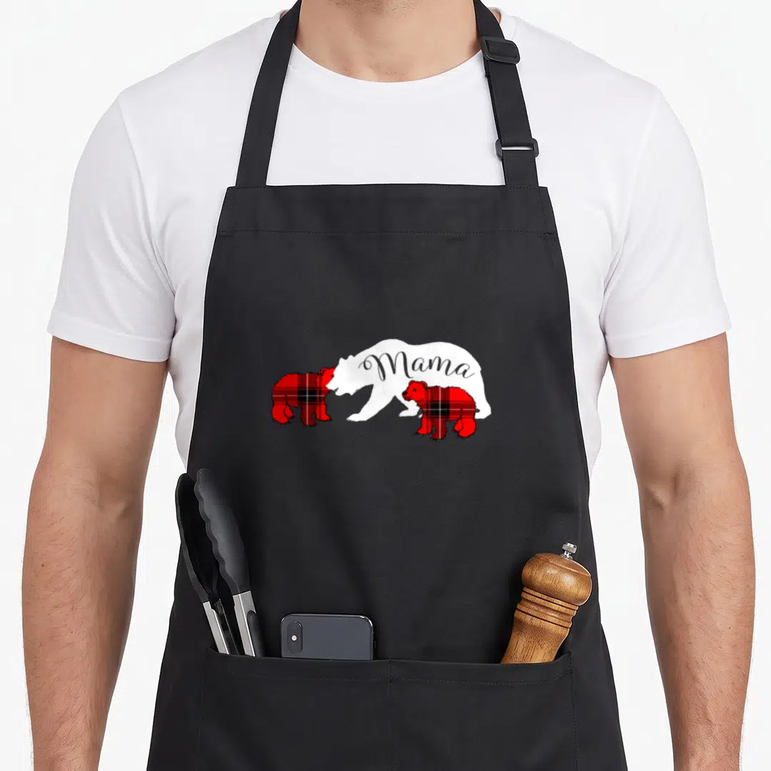 Cub cute bear apron - White Mama bear silhouette flanked by two red and black plaid cubs — shown on a black cotton canvas apron against a white background