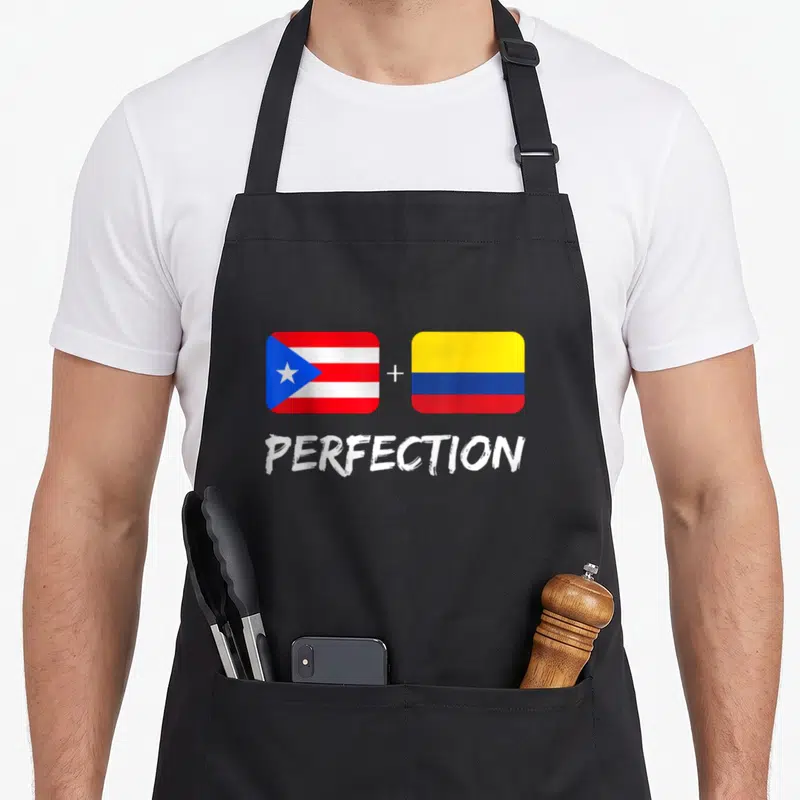 Perfection heritage aprons - Two flags connected by a plus sign above the word PERFECTION in red white blue and yellow — shown on a black cotton canvas apron against a white background