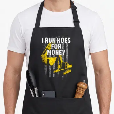 Operator run heavy canvas aprons - Distressed white text I RUN HOES FOR MONEY over yellow excavator with white stripes — shown on a black cotton canvas apron against a white background