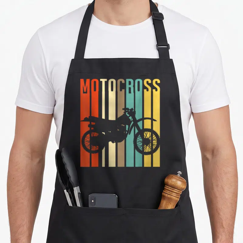 Silhouette bike apron - Grey motocross bike silhouette over red, orange, teal, and yellow vertical stripes — shown on a black cotton canvas apron against a white background