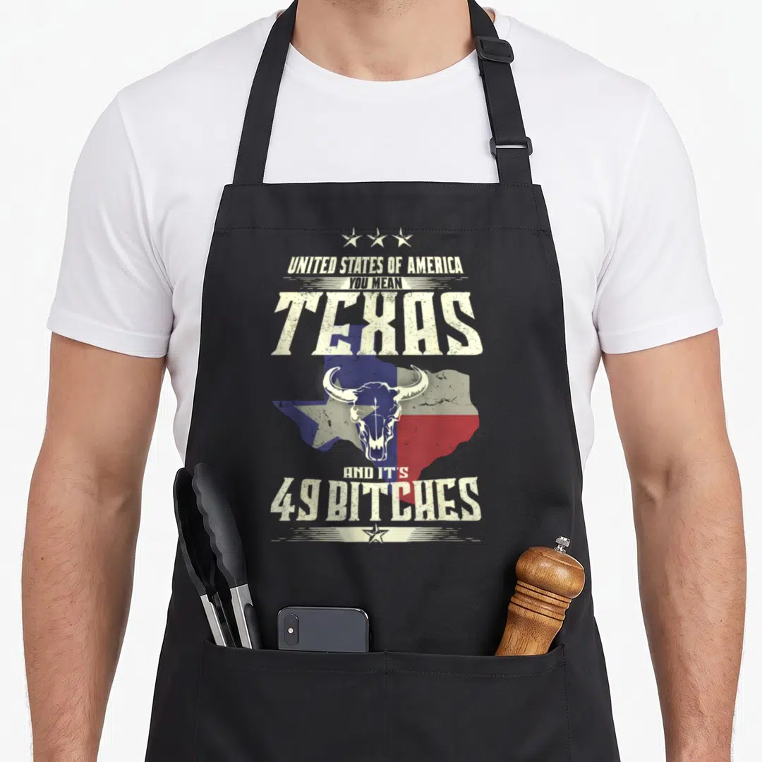 Funny state texas apron - Bull skull on Texas flag map with stacked sarcastic text in distressed white, blue, and red — shown on a black cotton canvas apron against a white background
