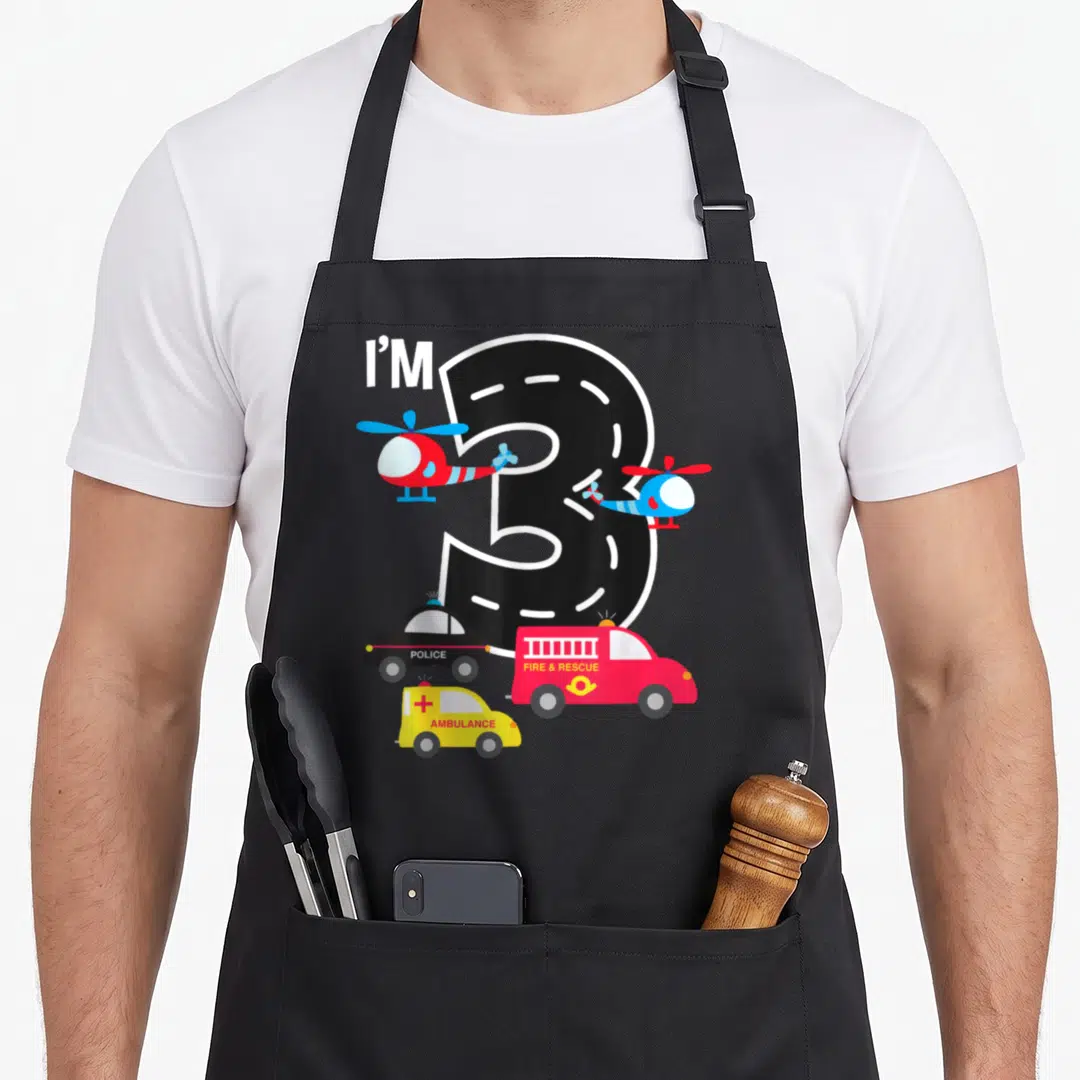 Fire police truck apron - Number 3 road design with police fire ambulance helicopters and I'M text — shown on a black cotton canvas apron against a white background