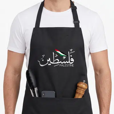 Arabic flag palestine apron - White Arabic calligraphy for Palestine with a small red green and black flag map above — shown on a black cotton canvas apron against a white background