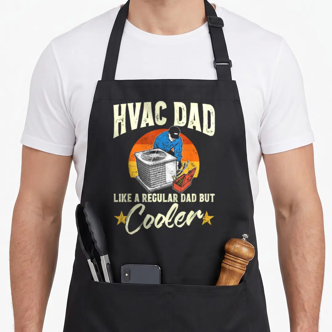 Hvac dad but apron - Retro HVAC technician fixing AC unit under striped sun with arched text and pun about being cooler — shown on a black cotton canvas apron against a white background