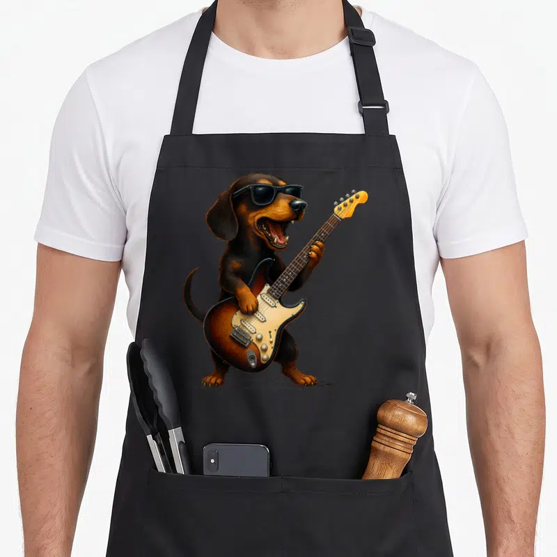 Rock dog apron - Realistic brown dachshund standing playing electric guitar with sunglasses — shown on a black cotton canvas apron against a white background