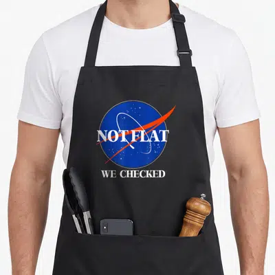 Flat science apron - Blue circle Earth graphic with red orbit line and white text NOT FLAT WE CHECKED — shown on a black cotton canvas apron against a white background