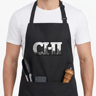 Chi chicago apron - CHI letters filled with black and white Chicago skyline photo — shown on a black cotton canvas apron against a white background
