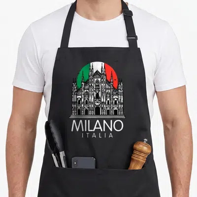 Milan italian aprons - Black white line drawing of Duomo cathedral over green white red circle with MILANO ITALIA text — shown on a black cotton canvas apron against a white background