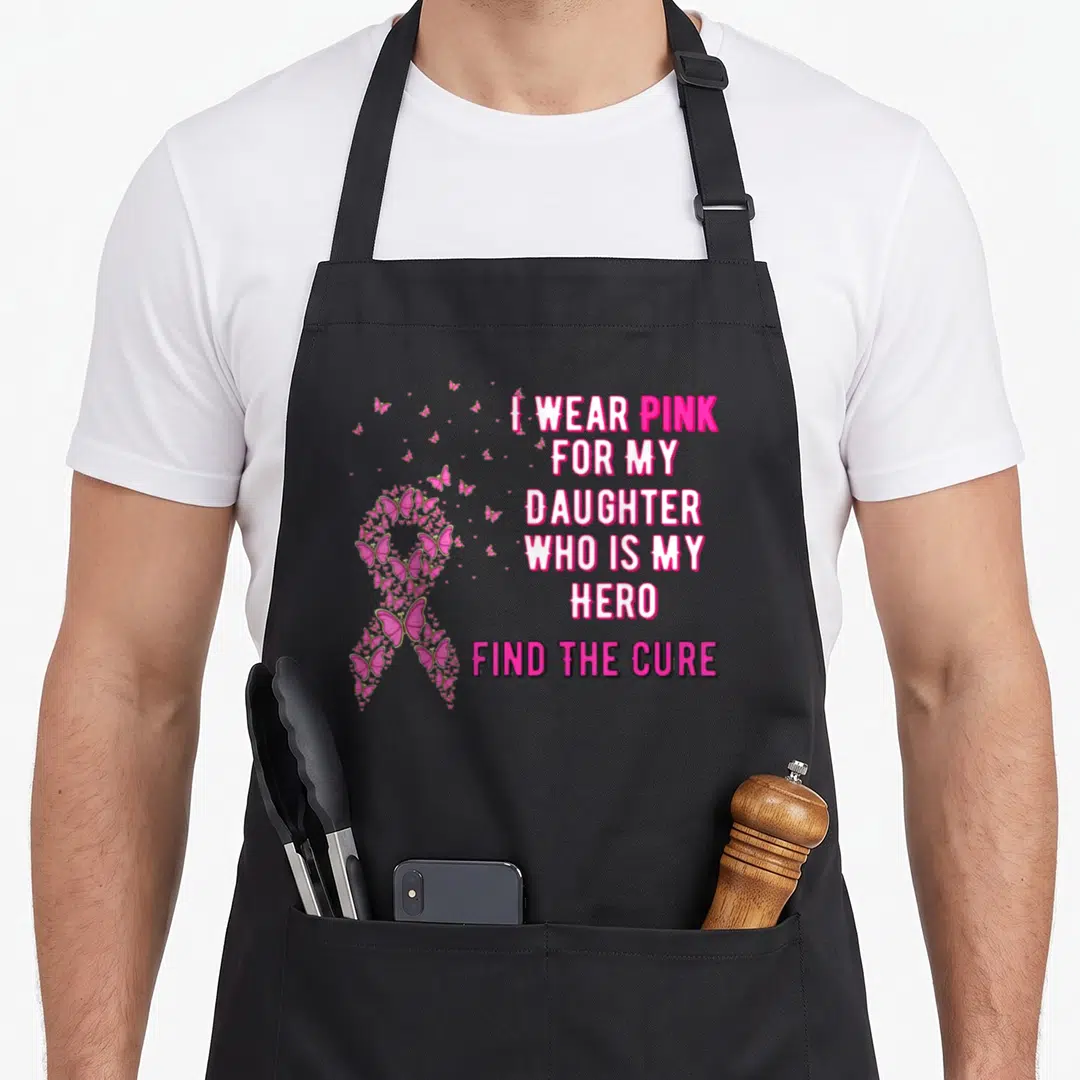 Cute daughter breast cancer awareness aprons - Pink awareness ribbon formed by small butterflies next to stacked text — shown on a black cotton canvas apron against a white background
