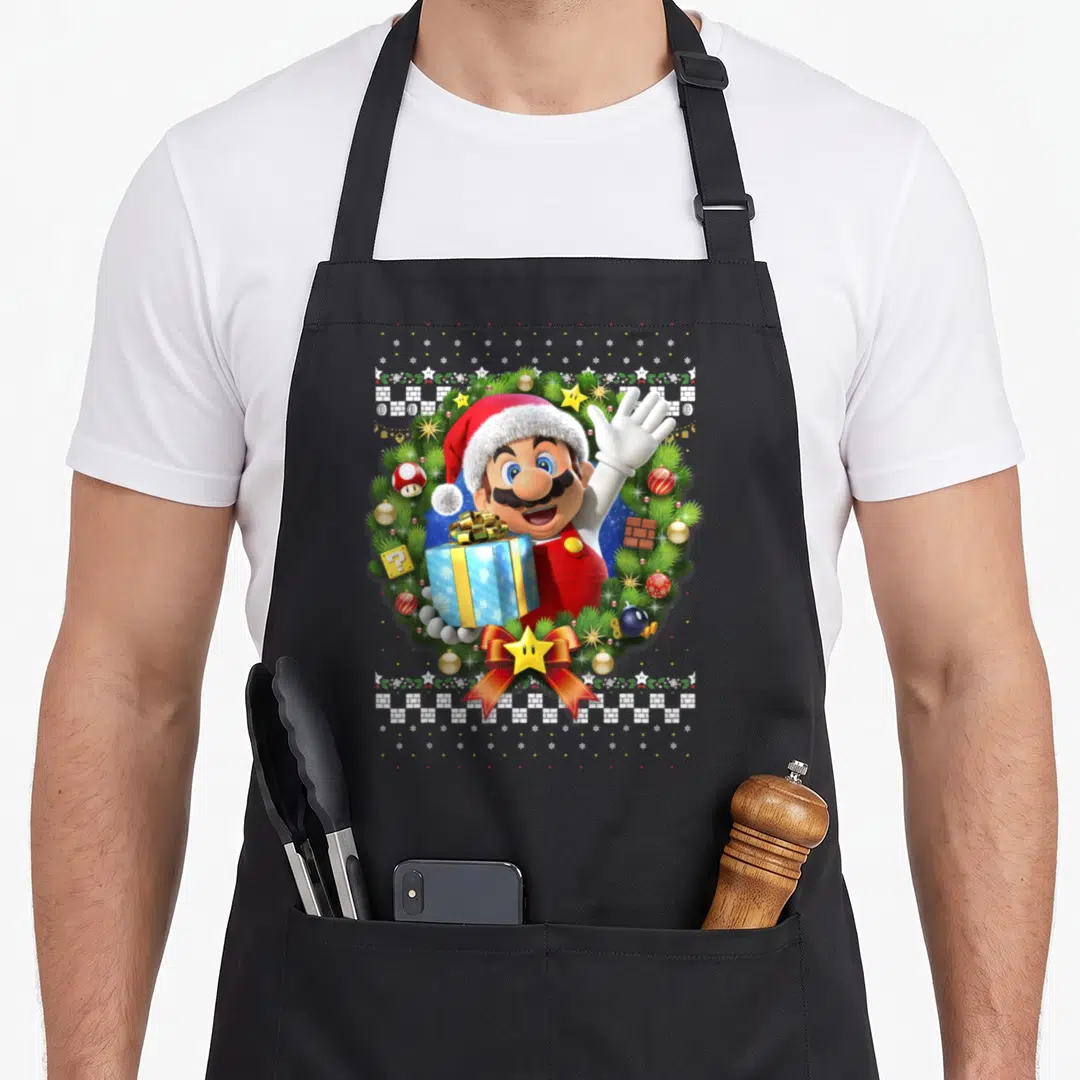 Wreath holiday christmas aprons - Mario in wreath holding blue gift with red hat, bricks, snowflakes, ornaments — shown on a black cotton canvas apron against a white background