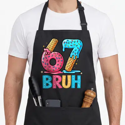 Six seven ice cream apron - Number 67 formed by pink donut and blue ice cream cone with BRUH text below — shown on a black cotton canvas apron against a white background