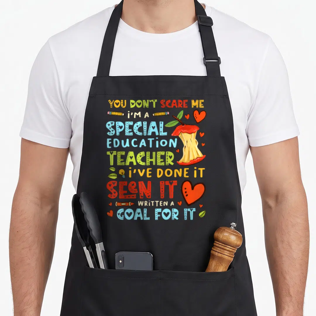Scare personalized teacher aprons - Stacked colorful text You Don't Scare Me Special Education Teacher with apple core — shown on a black cotton canvas apron against a white background