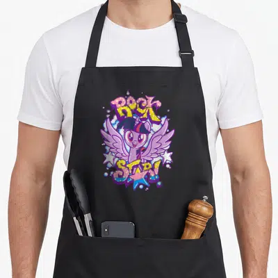 Twilight magic apron - Purple cartoon pony between graffiti text reading ROCK STAR! with yellow blue and pink splashes — shown on a black cotton canvas apron against a white background