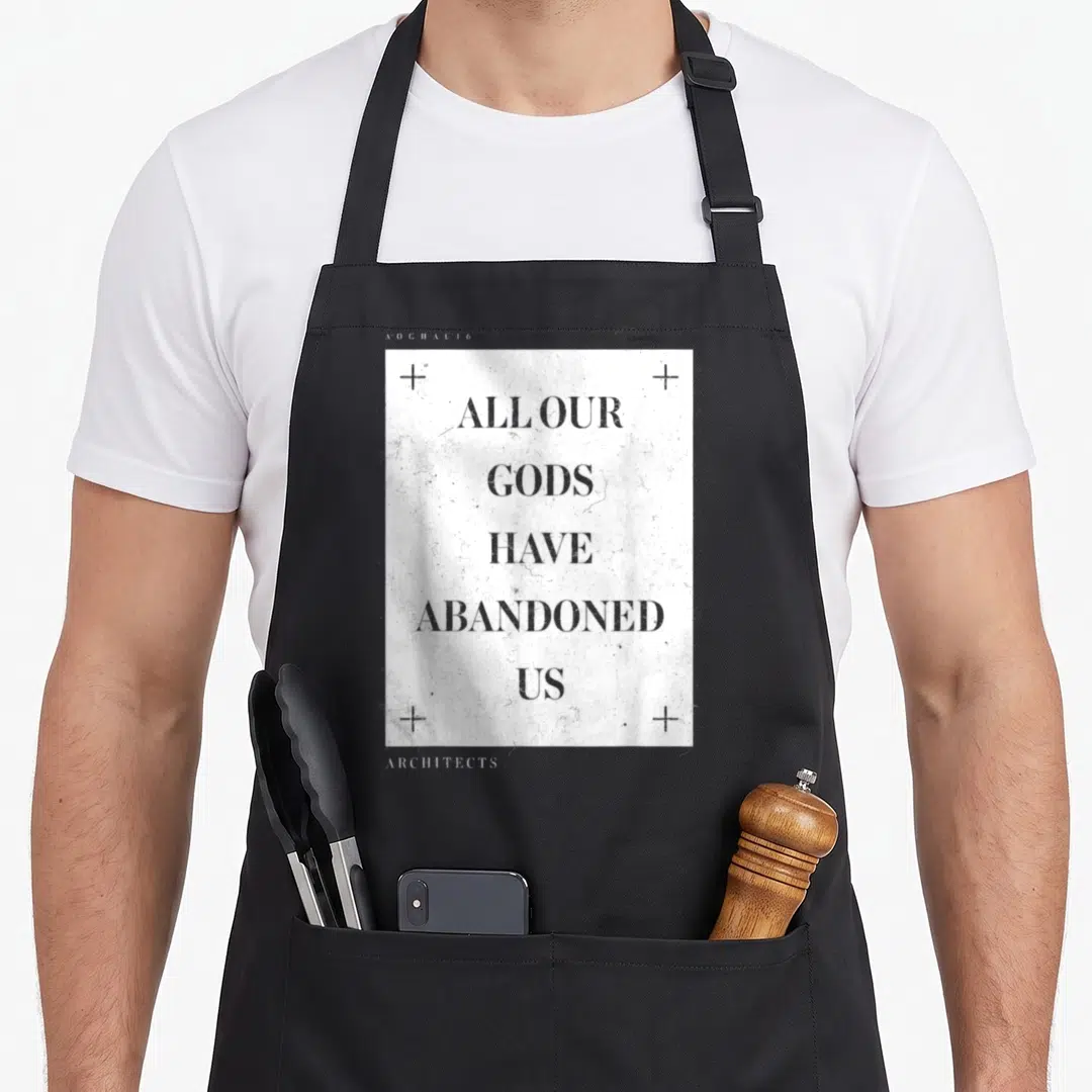 Our architect apron - Stacked grey text ALL OUR GODS HAVE ABANDONED US on distressed white background with four corner — shown on a black cotton canvas apron against a white background