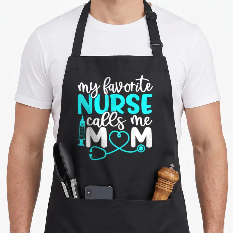 Call mother white nurse apron - my favorite nurse calls me mom text with cyan syringe and stethoscope heart — shown on a black cotton canvas apron against a white background