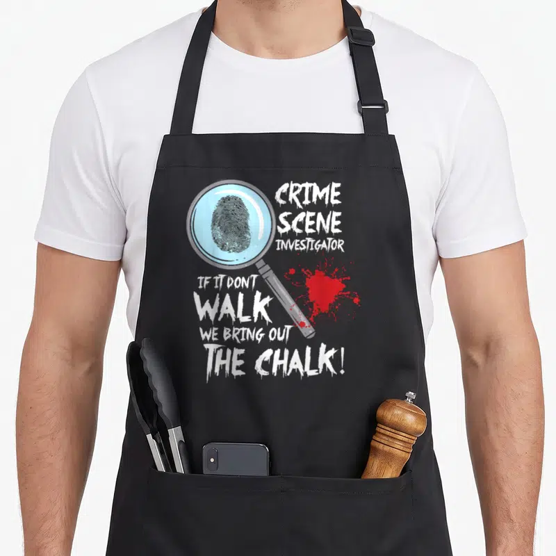 Crime investigator husband apron - Magnifying glass holding a fingerprint next to white text and red blood splatter — shown on a black cotton canvas apron against a white background