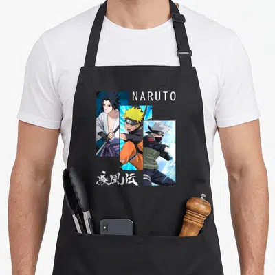 Panel general apron - Three diagonal anime character portraits with NARUTO text and Japanese Kanji in white orange blue — shown on a black cotton canvas apron against a white background