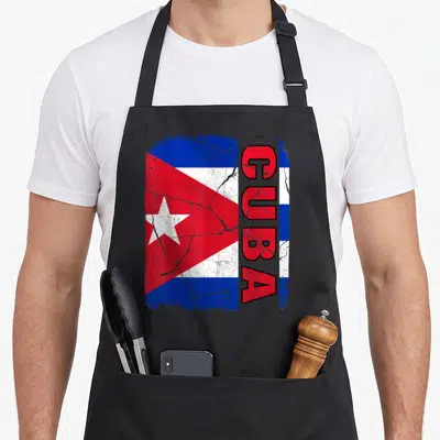 Cuban flag pride apron - Distressed Cuban flag print with vertical red CUBA text on blue white and red background — shown on a black cotton canvas apron against a white background