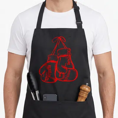 Boxing gloves and apron - Two red boxing gloves hanging from a red ribbon bow drawn in line art style — shown on a black cotton canvas apron against a white background