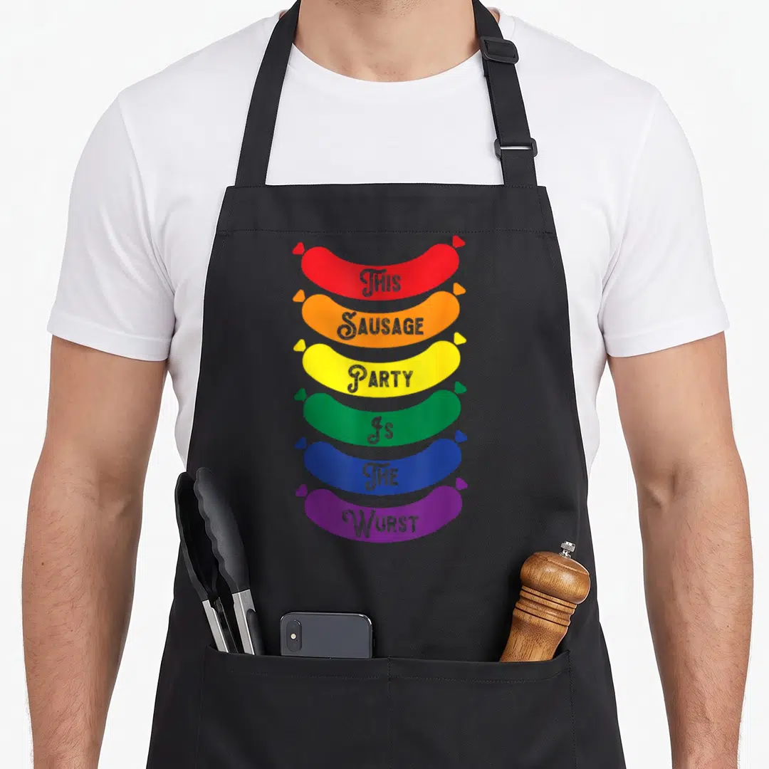 Oktoberfest gay pride apron - Six rainbow sausages stacked vertically with This Sausage Party Is The Wurst text — shown on a black cotton canvas apron against a white background