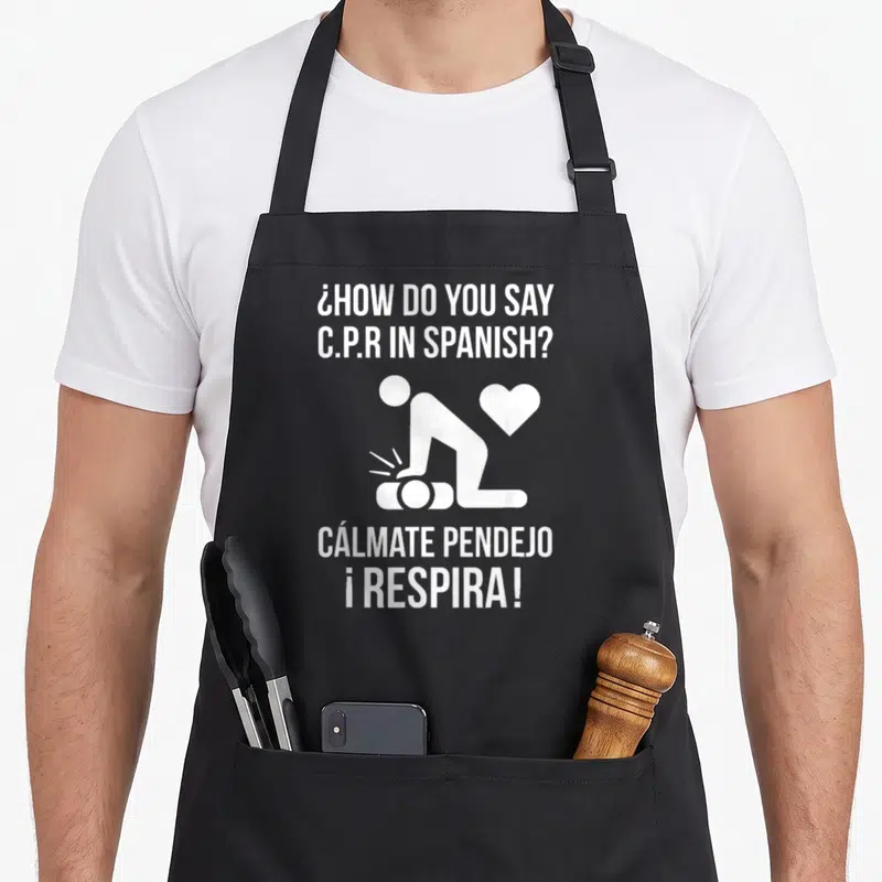 Calmate spanish aprons - White CPR silhouette and Spanish text asking how to say CPR in Spanish — shown on a black cotton canvas apron against a white background
