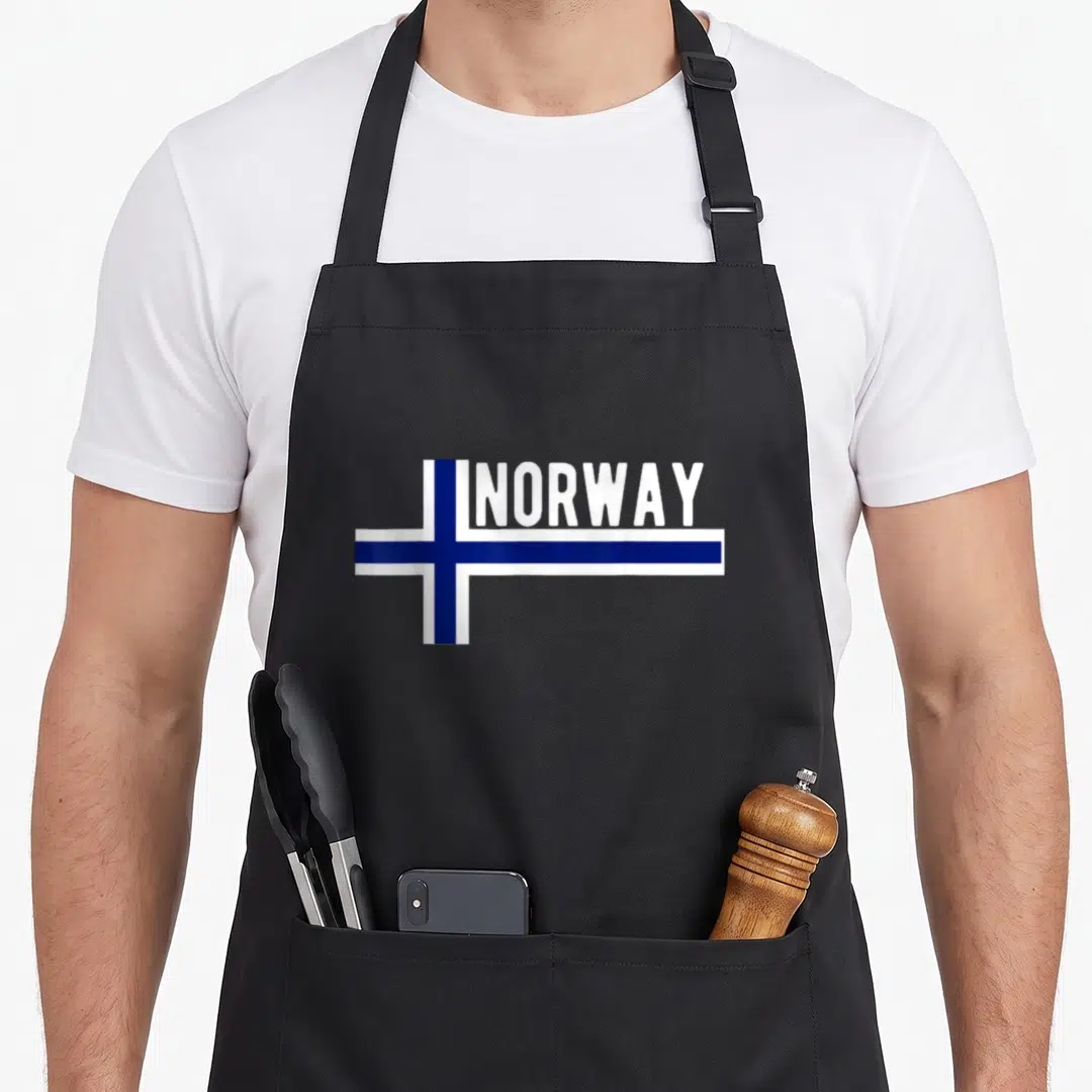 Flag scandinavian aprons - White and blue cross flag with NORWAY text on black apron — shown on a black cotton canvas apron against a white background