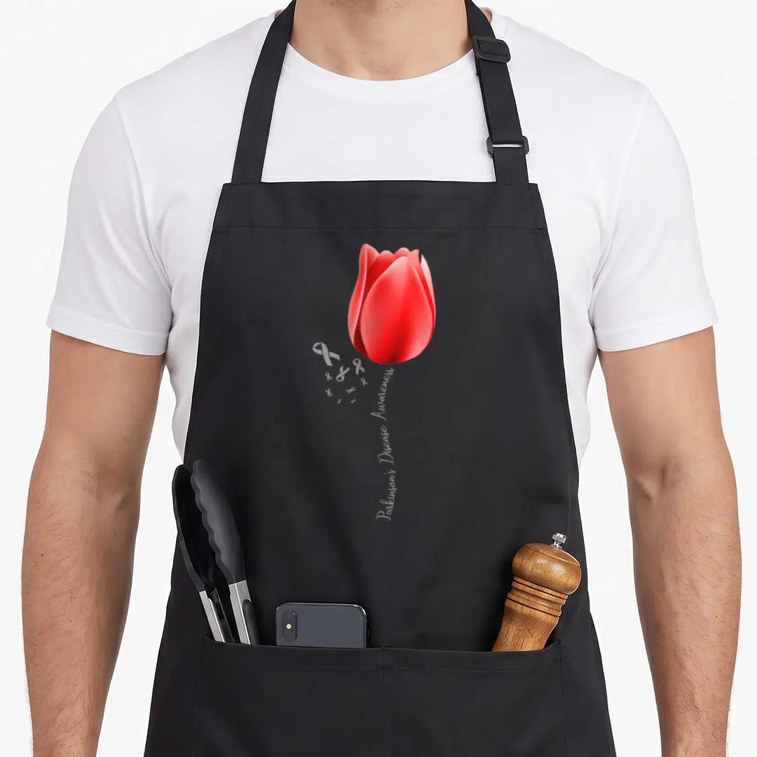 Disease tulip apron - Red tulip with Parkinson's Disease Awareness text stem and white ribbons — shown on a black cotton canvas apron against a white background