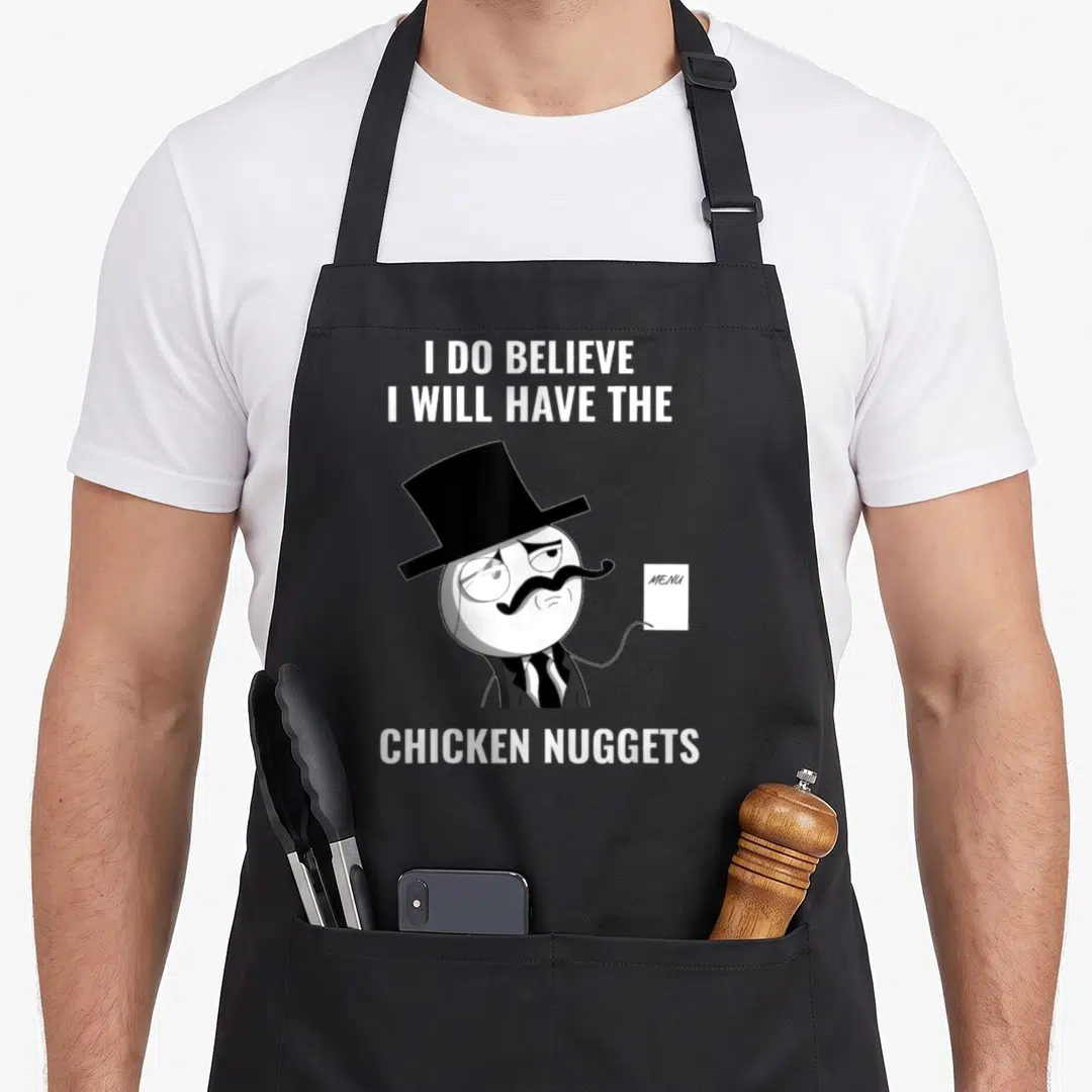Meme chicken print apron - Cartoon gentleman with top hat holding menu surrounded by I Do Believe I Will Have — shown on a black cotton canvas apron against a white background