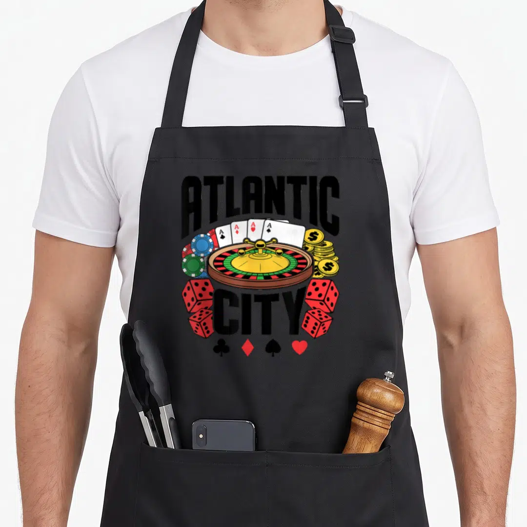 Atlantic casino aprons - Roulette wheel, four Aces, dice, chips, and Atlantic City text in cartoon style — shown on a black cotton canvas apron against a white background