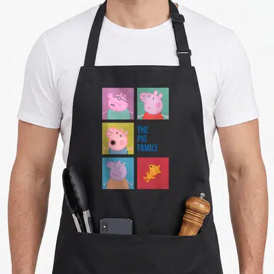 Cute family aprons - Cartoon pigs in grid with THE PIG FAMILY text in blue — shown on a black cotton canvas apron against a white background