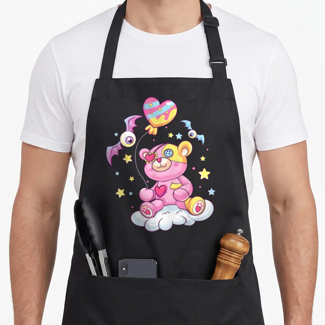 Teddy anime cooking apron - Pink teddy bear on white cloud with heart balloon and winged eyes — shown on a black cotton canvas apron against a white background
