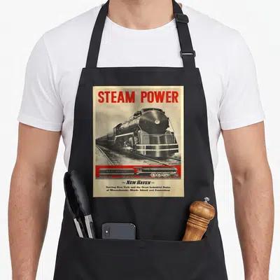 Power vintage steam apron - Red STEAM POWER text above black beige New Haven Railroad 1400 locomotive photo and side — shown on a black cotton canvas apron against a white background