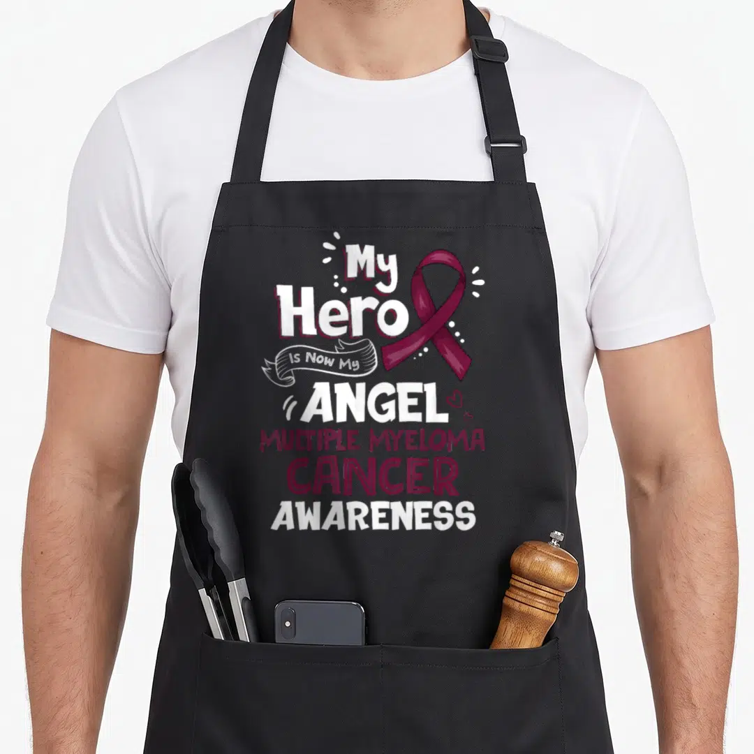 Mein myeloma awareness apron - Maroon ribbon and stacked white text reading My Hero Is Now My Angel Multiple Myeloma — shown on a black cotton canvas apron against a white background