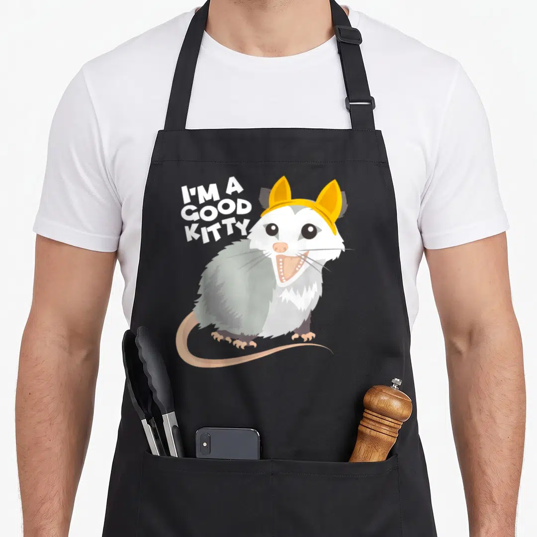 Fake kitty cat apron - Cartoon rat with yellow headband and text I'M A GOOD KITTY — shown on a black cotton canvas apron against a white background