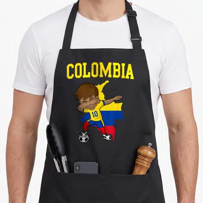 Colombia football apron - Cartoon boy dabbing over Colombia map with soccer ball in yellow blue red — shown on a black cotton canvas apron against a white background