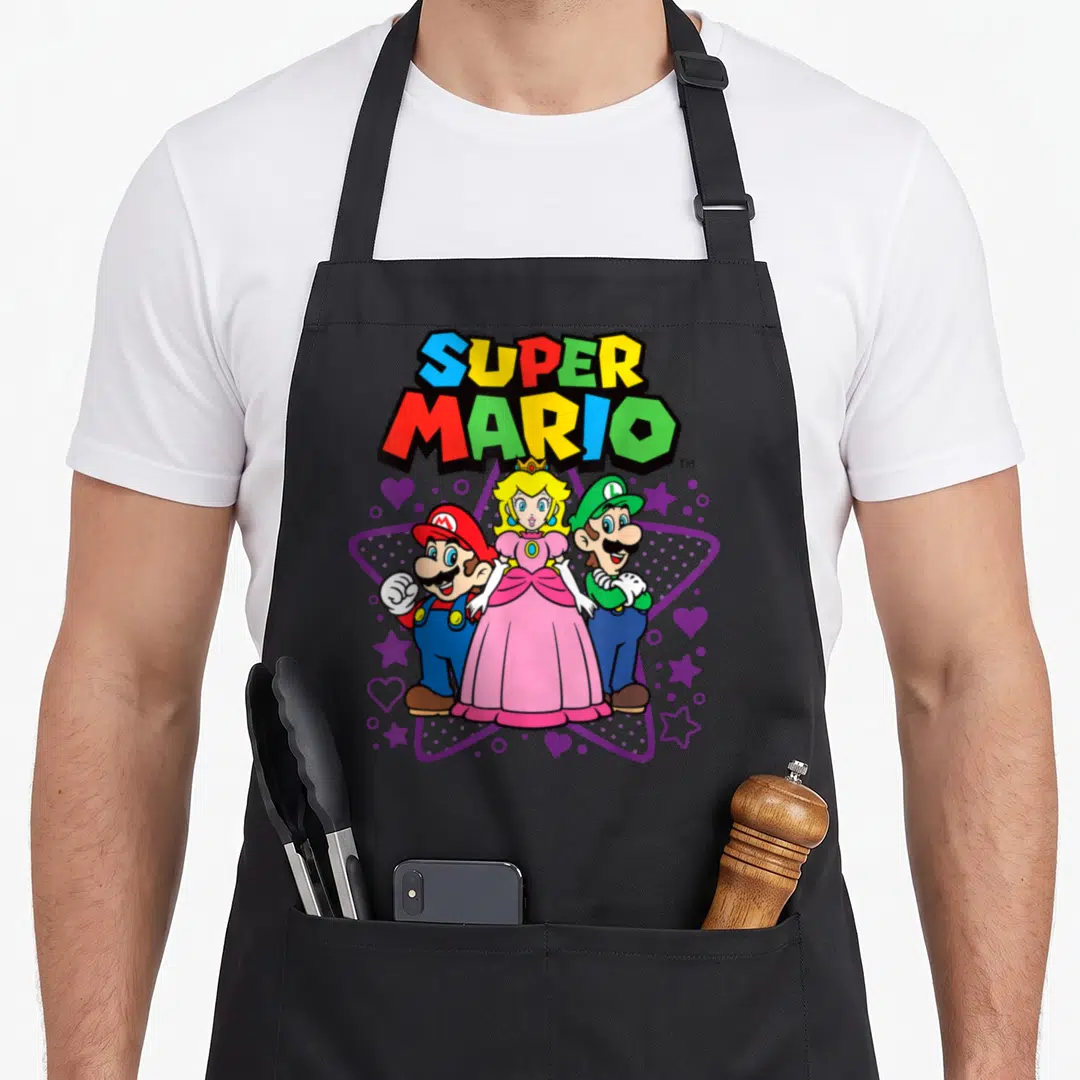 Trio peach apron - Super Mario, Peach, and Luigi in front of purple star with hearts and colorful text — shown on a black cotton canvas apron against a white background
