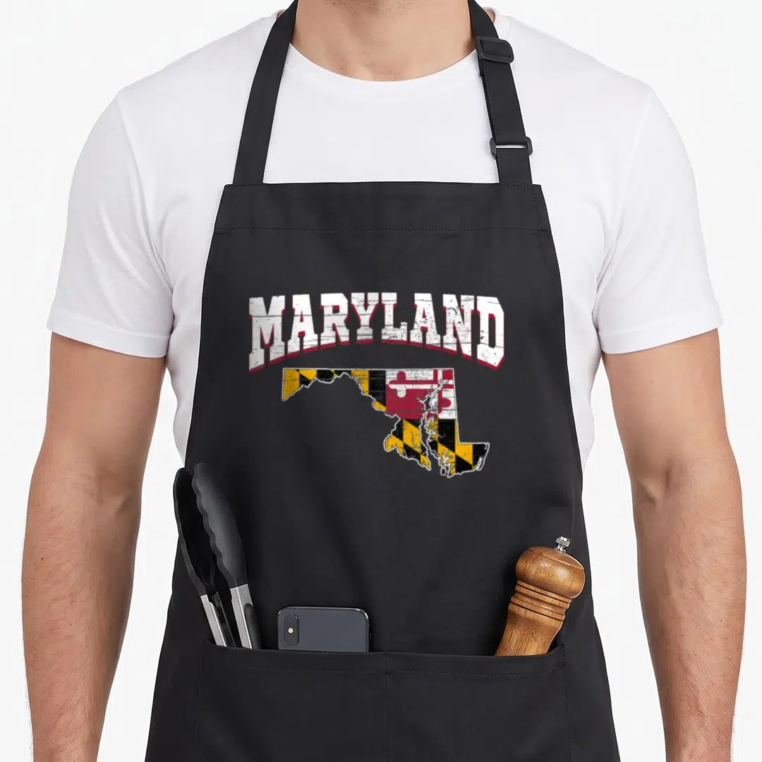 Land us aprons - Distressed Maryland text arching over a state map filled with the Maryland flag pattern in red, white — shown on a black cotton canvas apron against a white background