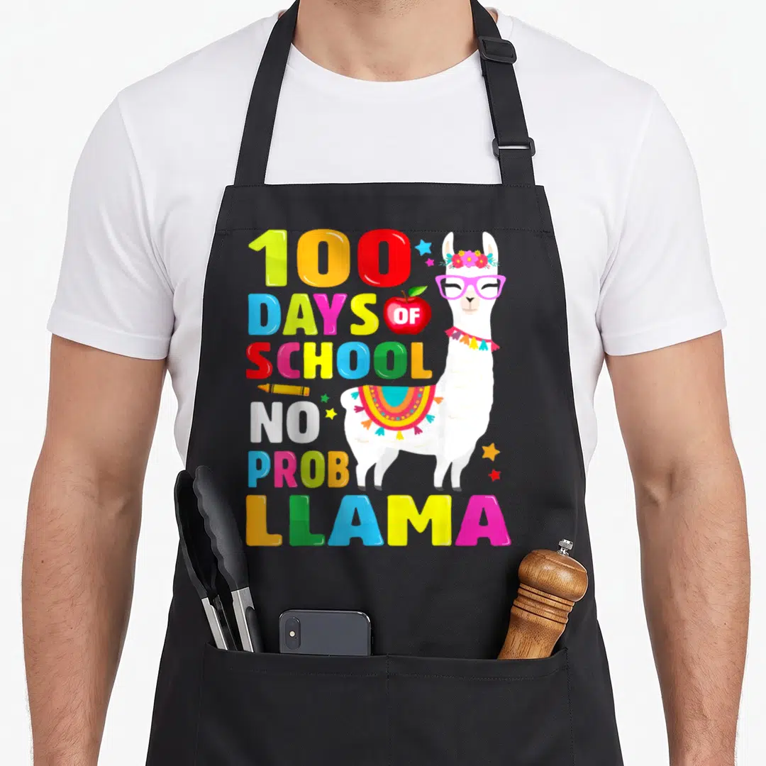 Probllama school apron - Cartoon llama with 100 DAYS OF SCHOOL NO PROB LLAMA text and crayon — shown on a black cotton canvas apron against a white background