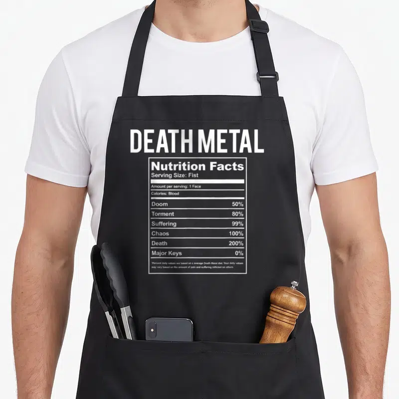 Brutal metal apron - White nutrition facts label with DEATH METAL text listing blood and suffering as ingredients — shown on a black cotton canvas apron against a white background