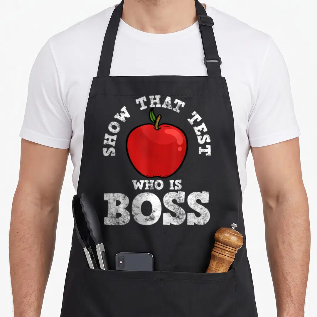 Student exam teacher apron - Red cartoon apple with white text showing test boss — shown on a black cotton canvas apron against a white background