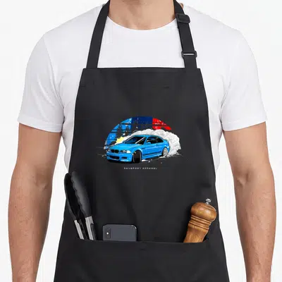 E46 drifting apron - Blue cartoon car drifting with white smoke and colorful sun background — shown on a black cotton canvas apron against a white background