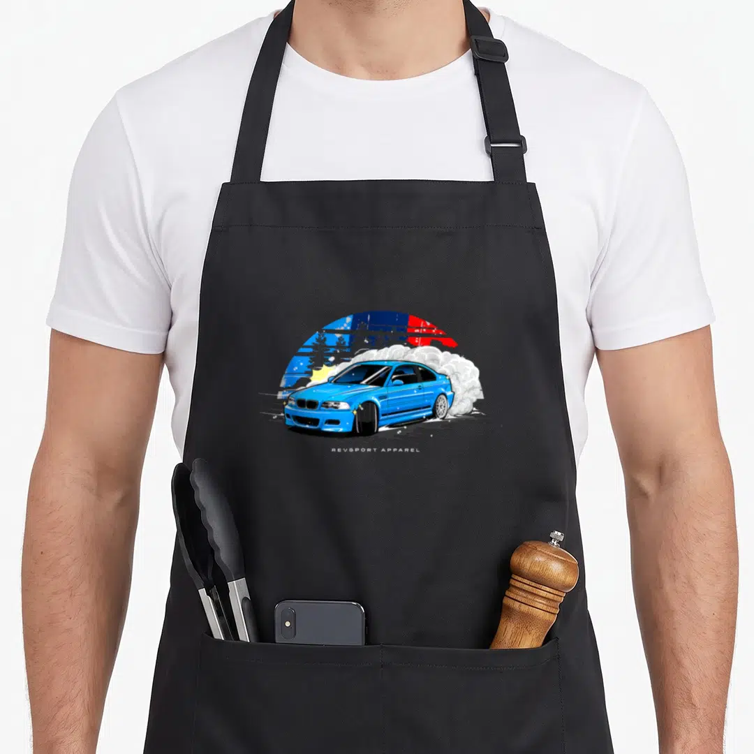 E46 drifting apron - Blue cartoon car drifting with white smoke and colorful sun background — shown on a black cotton canvas apron against a white background