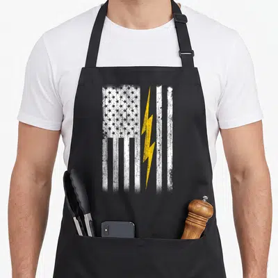 Funny flag electrician apron - Distressed white flag with yellow lightning bolt overlay on right side stripes — shown on a black cotton canvas apron against a white background
