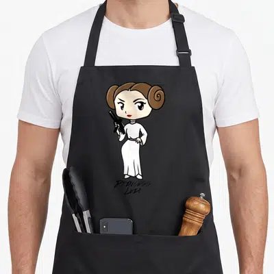 Vintage cartoon apron - Cartoon Princess Leia holding blaster with white dress and printed name below — shown on a black cotton canvas apron against a white background