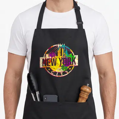Funny pride new york apron - Distressed circular NYC skyline emblem with red yellow blue green purple paint splatters — shown on a black cotton canvas apron against a white background